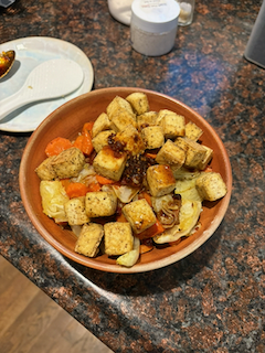 Delicious tofu in a bowl with rice, vegetables, and chili crisp.
